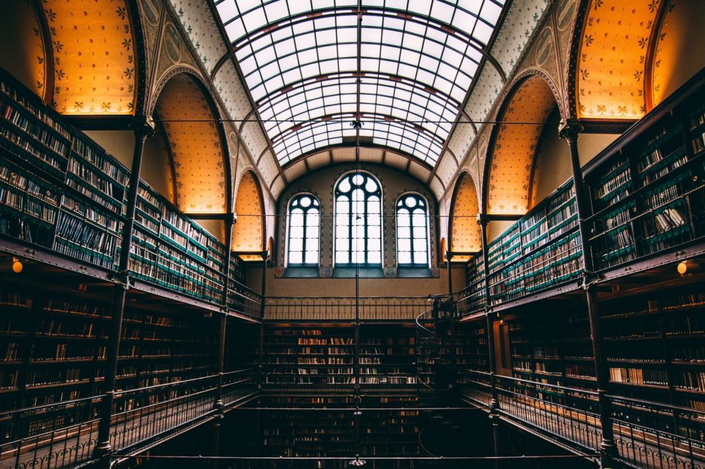 Room with glass arched ceiling and walls lined with many rows of books